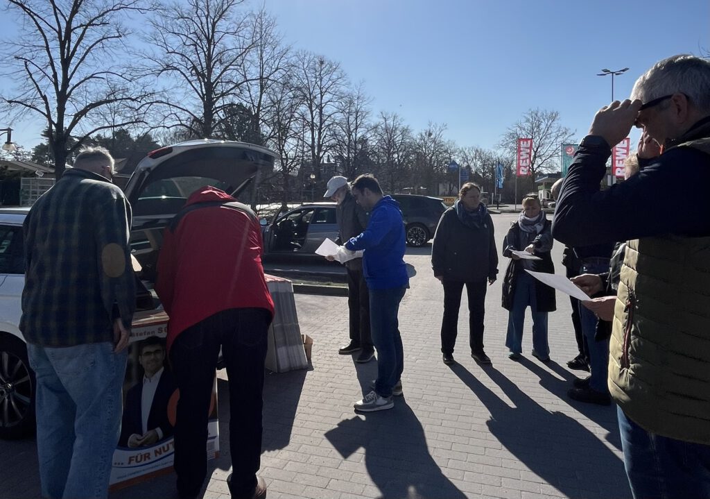 Gruppe von Unterstützenden beim Plakate aufhängen 